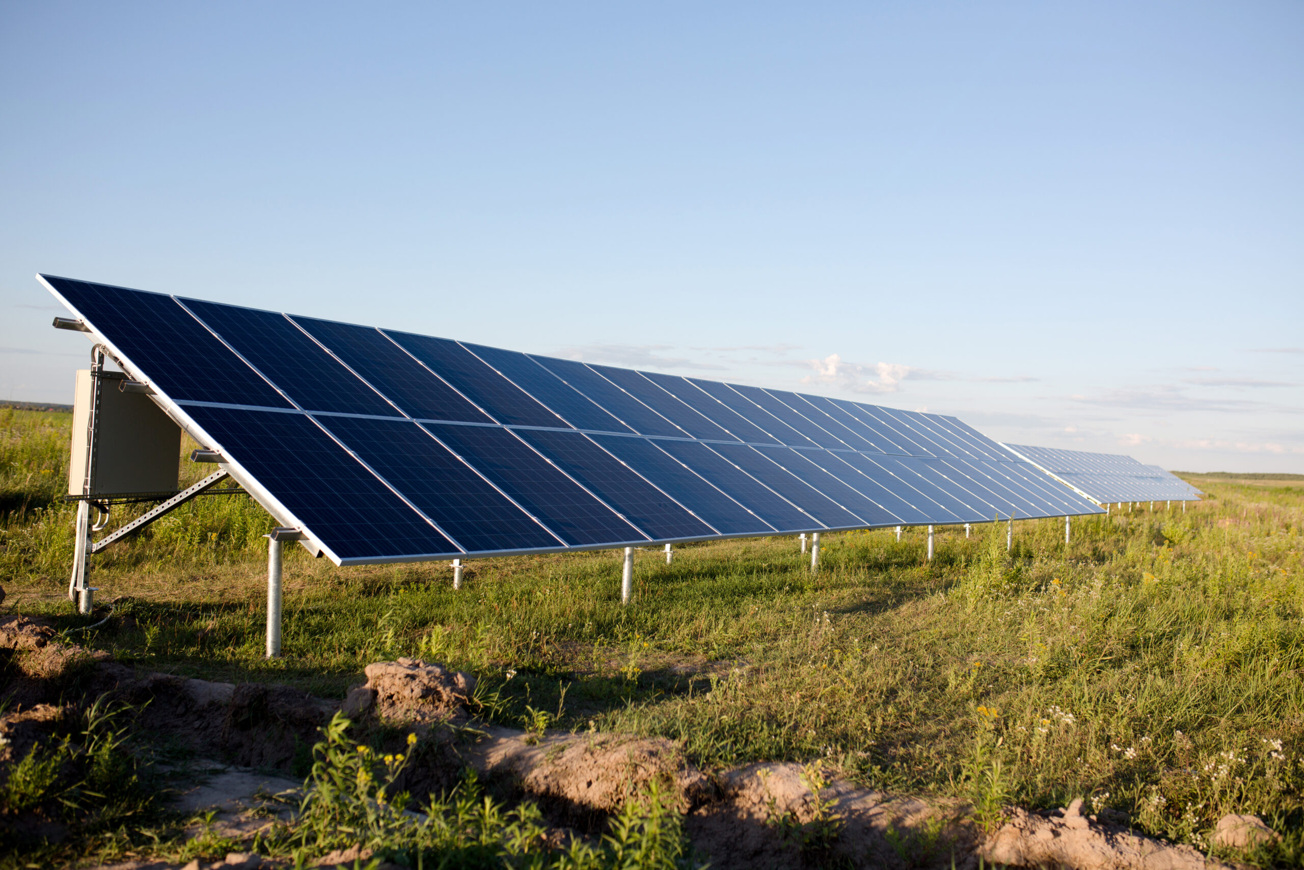 Solar panels, blue sky and green field